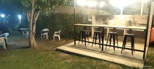 a bar with stools in a backyard at night at La Arcadia in Mina Clavero