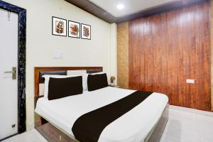 a bedroom with a bed and a wooden wall at HOTEL O RAJDHANI in Kānpur