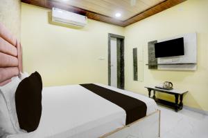 a bedroom with a bed and a flat screen tv at HOTEL O RAJDHANI in Kānpur
