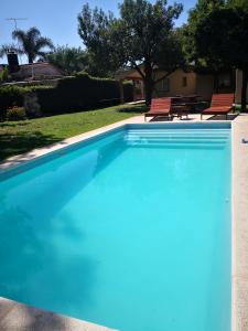 a blue swimming pool with two chairs in a yard at Descanso de Caroya in Colonia Caroya
