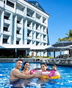 a family in the swimming pool at a resort at Olas Altas Inn Hotel & Spa in Mazatlán