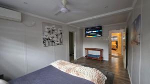 a bedroom with a bed and a tv on the wall at THE PONT port Edward UNIT 1 in Port Edward +19 photos