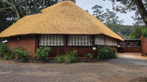 a hut with a thatched roof with plants in front at THE PONT port Edward UNIT 1 in Port Edward