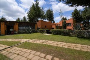 a house with a yard with a brick walkway at Rancho Cumbre Monarca in La Ciénega