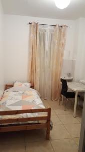 - une chambre avec un lit, une table et un bureau dans l'établissement Chambres à PARIS, à Ivry-sur-Seine