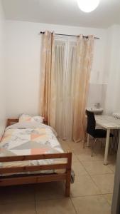 a bedroom with a bed and a table and a desk at Chambres à PARIS in Ivry-sur-Seine