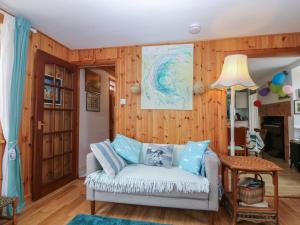 a living room with a couch and wooden walls at Dookers' Hoose in Buckie