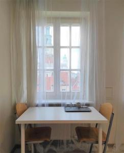 a white table with chairs in front of a window at Rynek 5 in Poznań