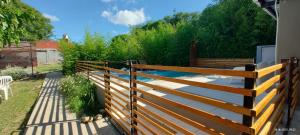 a wooden fence next to a backyard with a pond at La Arcadia in Mina Clavero