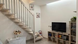 a living room with a staircase and a flat screen tv at Alloggio Turistico Francy House in Lido dei Pini +31 photos