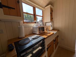 a small kitchen with a stove and a microwave at The Beeches in Scarisbrick +10 photos