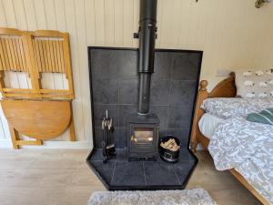 a wood stove in a room with a bed at The Beeches in Scarisbrick