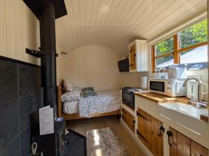 a kitchen with a stove and a bed in a room at The Beeches in Scarisbrick