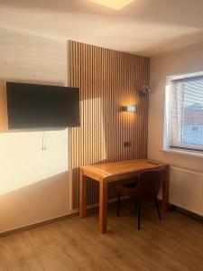 a room with a desk with a chair and a television at City Event Hotel in Dinslaken