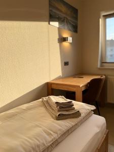 a room with a bed and a desk and a table at City Event Hotel in Dinslaken