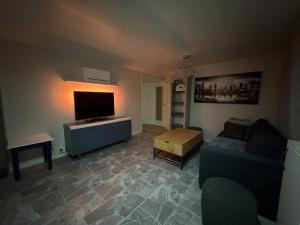a living room with a couch and a flat screen tv at Apparent with 2 bedrooms for rent in Kirkenes