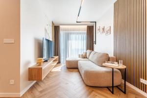 a living room with a couch and a tv at Global Apartments Katowice in Katowice