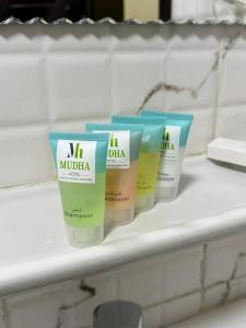 a row of four bottles of moisturizers on a shelf at Mudha Hotel in Hargeysa