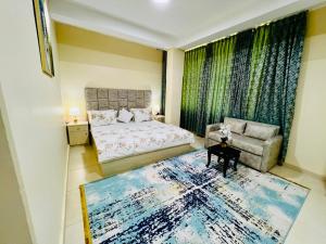 a bedroom with a bed and a couch and a chair at Mudha Hotel in Hargeysa