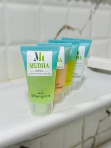 a row of four sunscreen bottles on a shelf at Mudha Hotel in Hargeysa