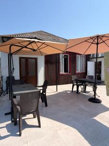 a patio with tables and umbrellas on a patio at Light in August in Kobuleti