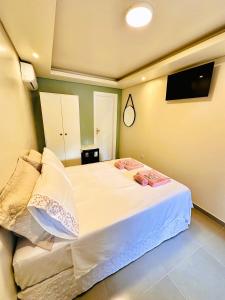 a bedroom with a bed with white sheets and pillows at Pousada Cair do Sol in Ilha do Mel