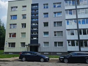 two cars parked in front of a building at Taikos apartamentai in Utena