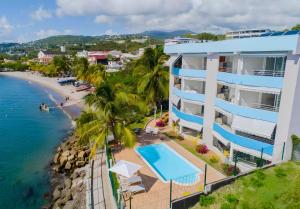 Luftaufnahme eines Resorts mit Swimmingpool und Strand in der Unterkunft Hotel Pelican in Schœlcher