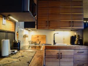 a kitchen with wooden cabinets and a sink at Casa Nilhue Camino a Farellones in Lo Barnechea +4 photos