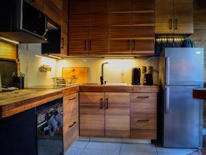 a kitchen with wooden cabinets and a stainless steel refrigerator at Casa Nilhue Camino a Farellones in Lo Barnechea