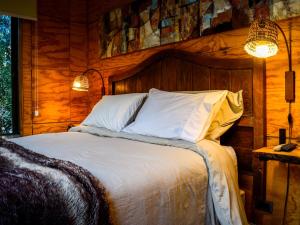 a bedroom with a bed with a wooden wall at Casa Nilhue Camino a Farellones in Lo Barnechea
