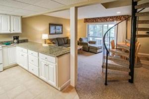 a kitchen with a staircase and a living room at Tanglwood Resort in Hawley