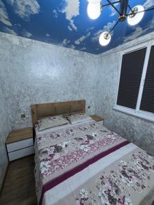 a bedroom with a bed and a blue ceiling at Apartment in Jvari in Jvari