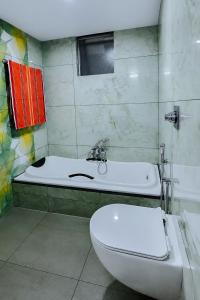 a bathroom with a white toilet and a sink at Sansa Villa in Athirappilly