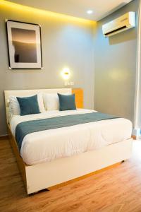 a bedroom with a large white bed with blue pillows at The Mimshach in Asese