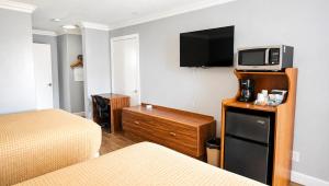 a hotel room with two beds and a tv on a wall at Magnuson Hotel Blythe in Blythe