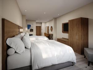 a bedroom with a large white bed and a television at Holiday Inn Express & Suites Southfield - Detroit in Southfield