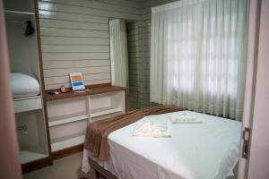 a bedroom with a bed with towels on it at Sítio Monte Frederico in Nova Trento +5 photos