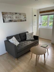 a living room with a gray couch and a table at The White Farm in Skanderborg
