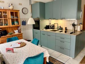 a kitchen with a table and blue cabinets at Historisches Ganghaus "Bluebelle" in Lübeck