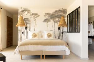ein Schlafzimmer mit einem Bett und Bäumen an der Wand in der Unterkunft Hôtel & Spa A Cala - Suites Piscines Privées - Adults Only in Conca