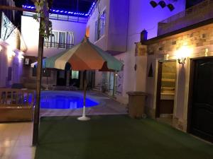 a pool with an umbrella next to a house at Guest House in Luxor +23 photos