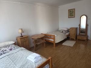a room with two beds and a table and a mirror at Haus der Sonne Apartment in Blaufelden