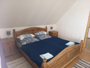 a bedroom with a wooden bed with blue sheets and pillows at Haus der Sonne Apartment in Blaufelden