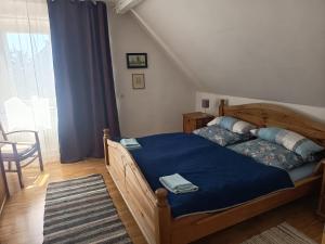 a bedroom with a wooden bed with a blue blanket at Haus der Sonne Apartment in Blaufelden +5 photos