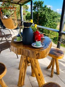 a wooden table with a vase and cups on it at Pousada Estância Bela Vista in Santa Teresa