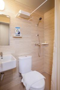 a bathroom with a toilet, sink, and shower stall at Verse Lite Hotel Gajah Mada in Jakarta