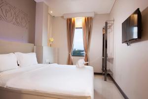 a hotel room with a bed and a television at Verse Lite Hotel Gajah Mada in Jakarta