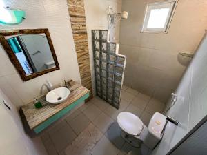 a bathroom with a toilet and a sink and a mirror at Wind & Sun Kite Pousada in Canoa Quebrada +26 photos