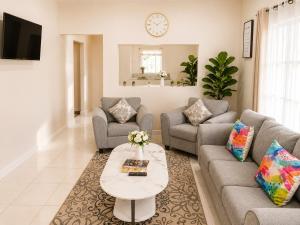a living room with two couches and a table at AG3K Oasis in Buccoo